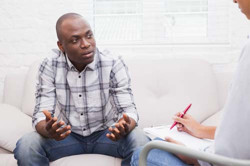 man gesturing in addiction treatment program therapy session