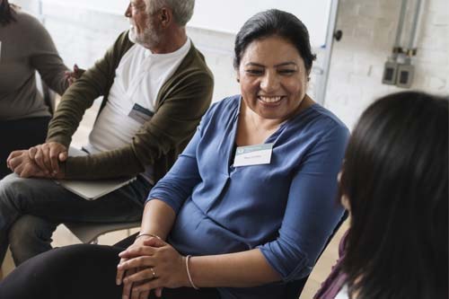 woman wearing name tag at a group substance abuse treatment meeting