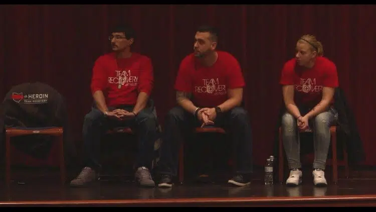 a panel of people listen to a crowd