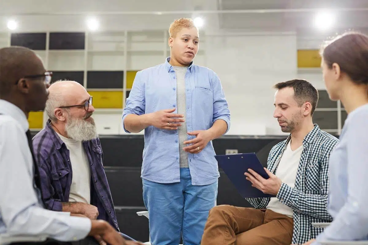 person standing up in group to ask for Addiction Help