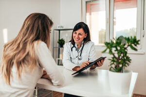 doctor explaining Prescription Drug Addiction Treatment Programs to woman