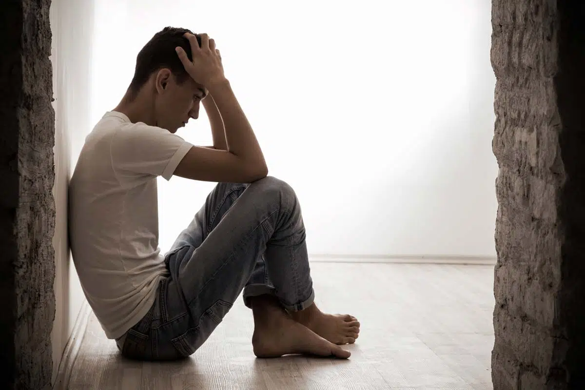 man sitting on floor struggling with Types of Mental Illness
