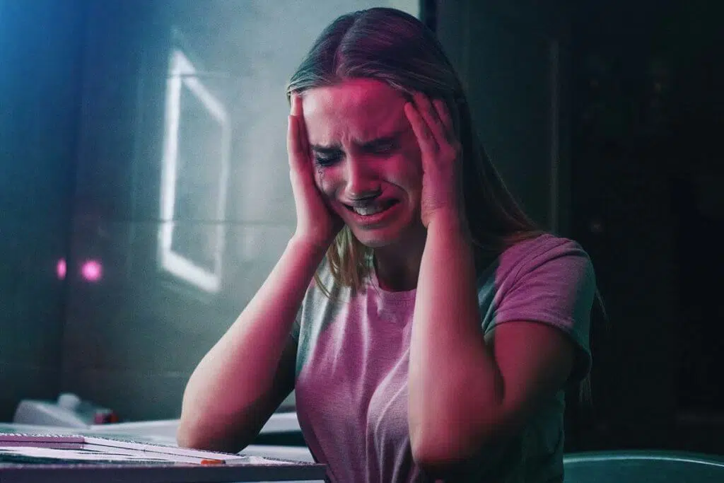 pained woman holding head from the Long Term Effects of Meth Abuse