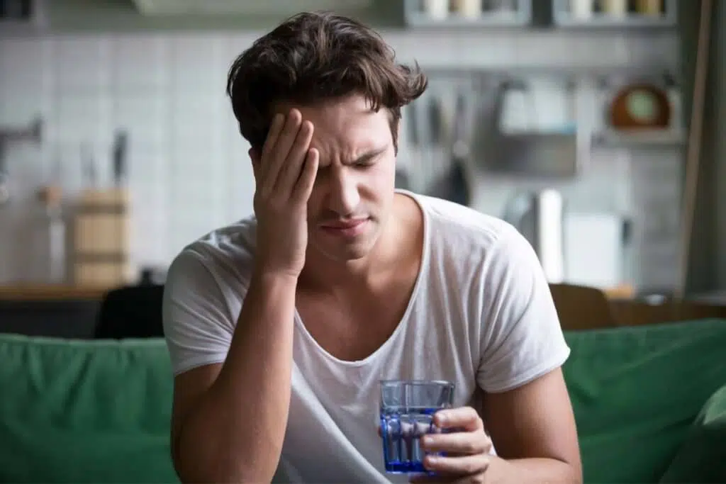 man with headache showing Symptoms of Addiction