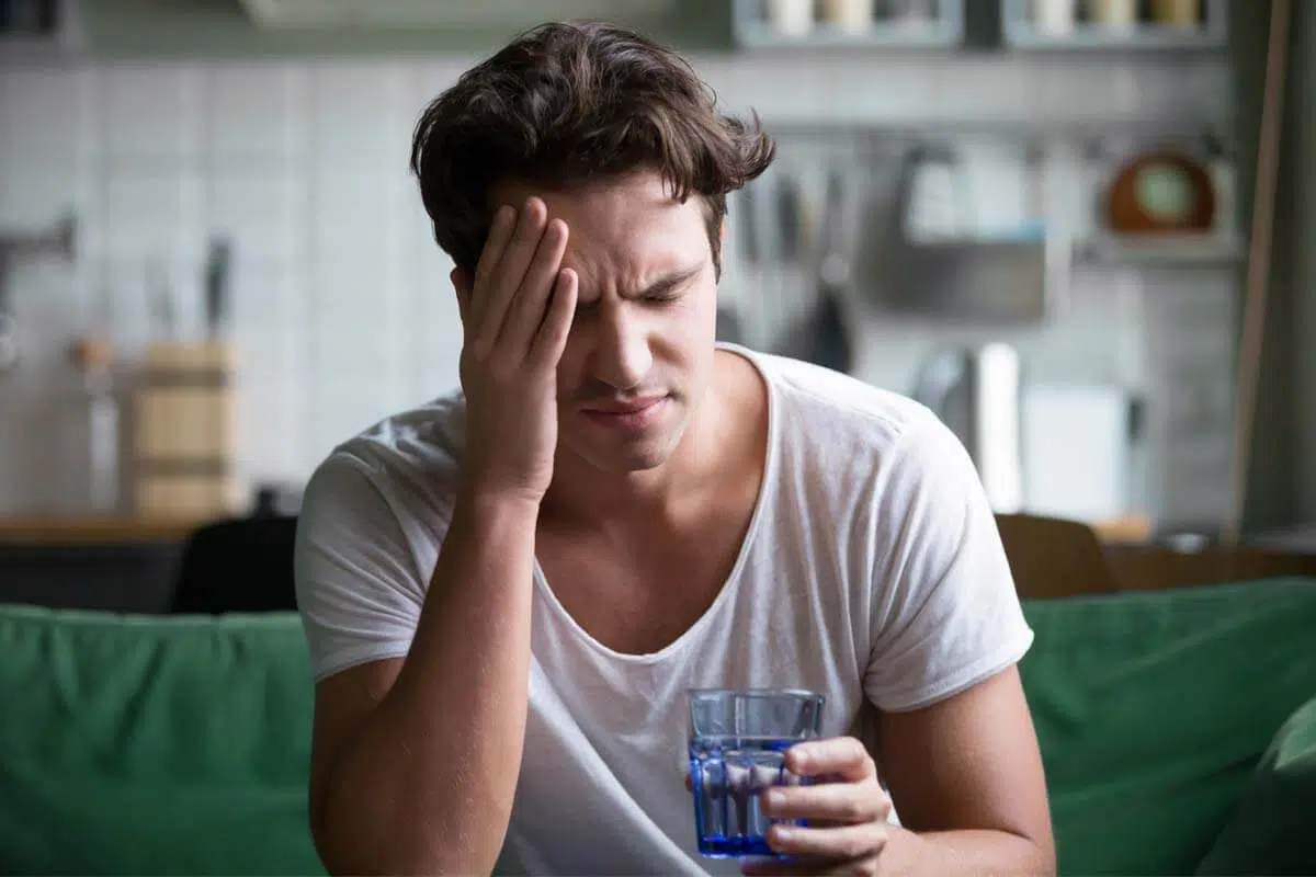 man with headache showing Symptoms of Addiction