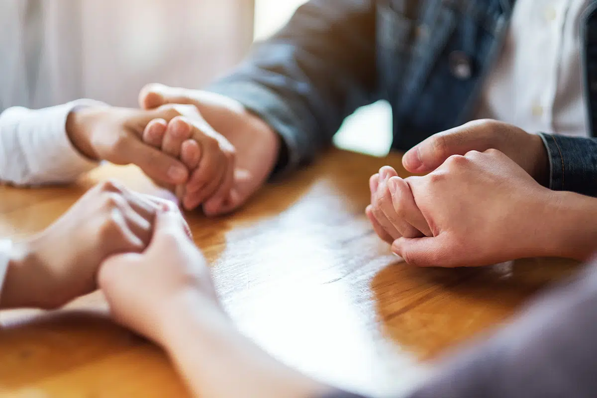 family holding hands to begin helping an addict