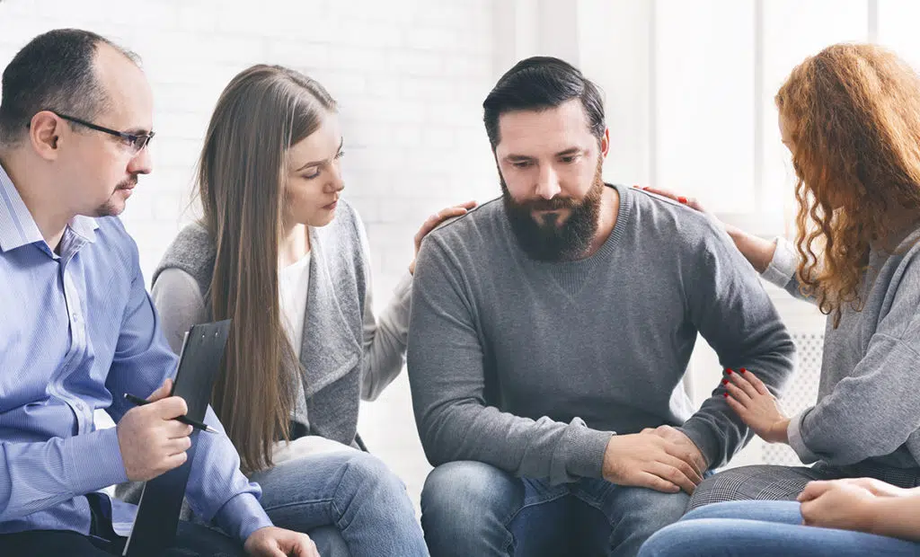 family encouraging man to enter a drug rehab center