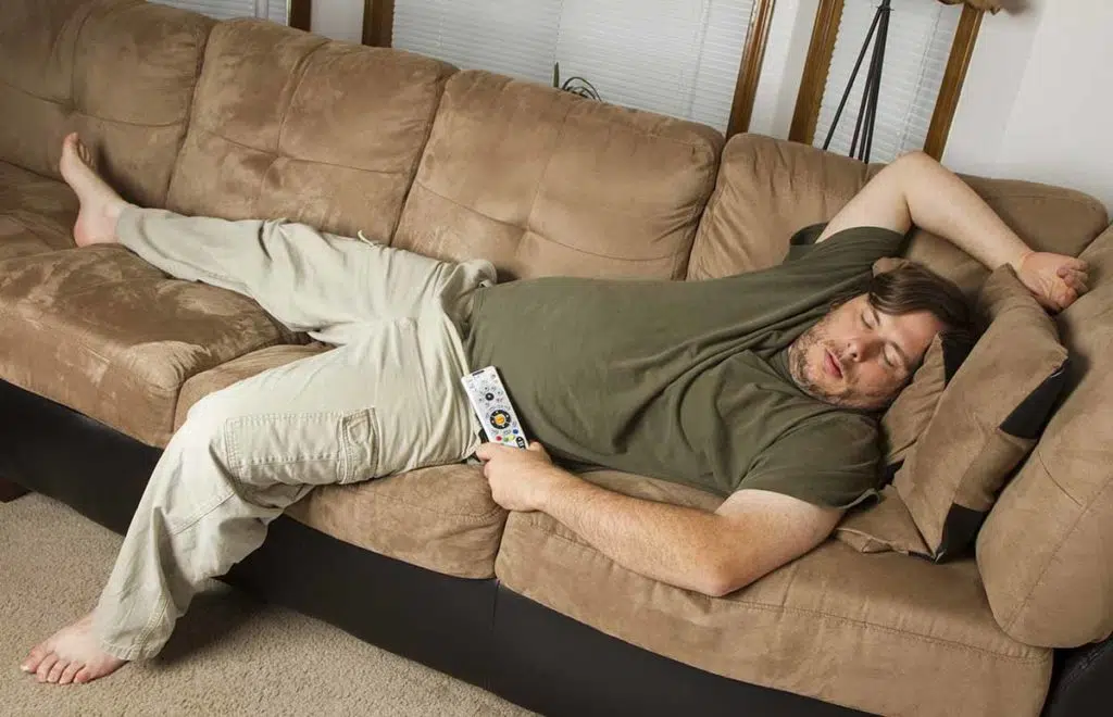 man laying on couch experiencing marijuana side effects