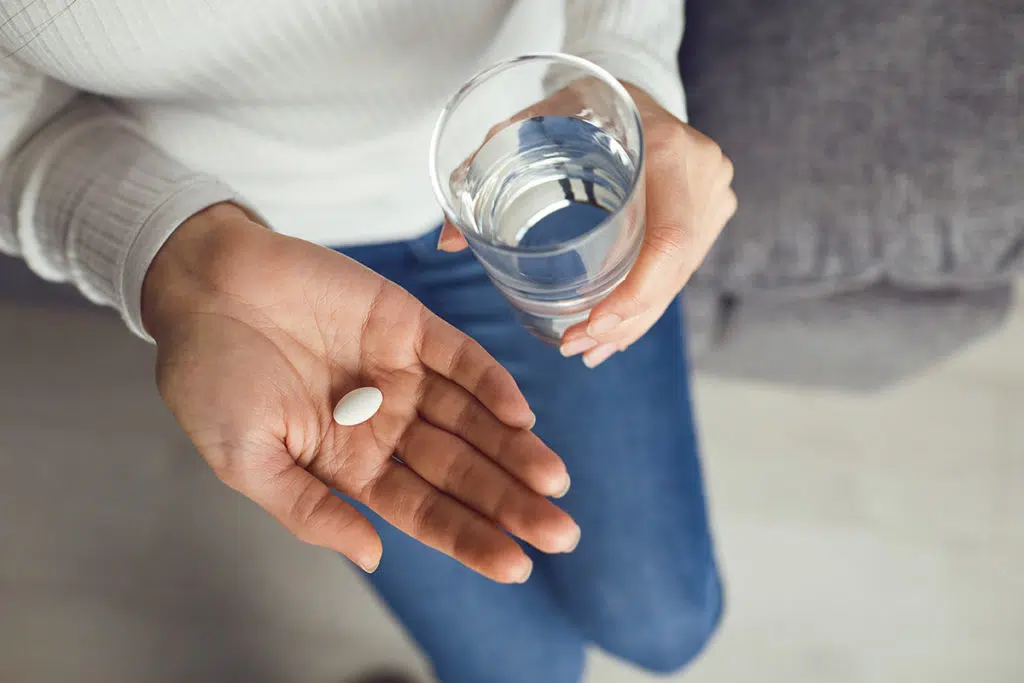 woman takes a pill and starts to spot her painkiller addiction