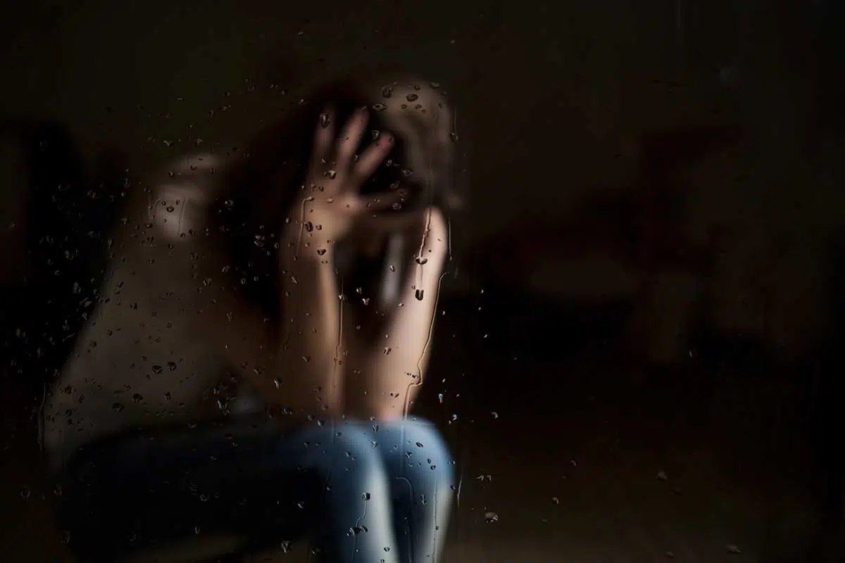 person hidden in dark dealing with trauma
