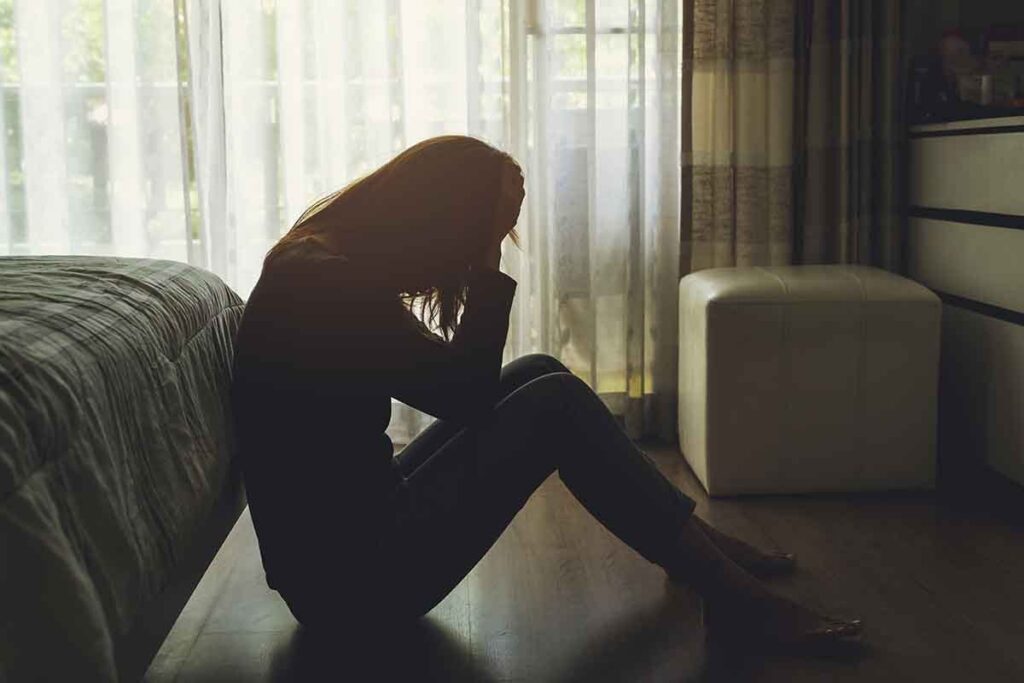 individual sitting on the floor in the dark needing drug detox centers in ohio
