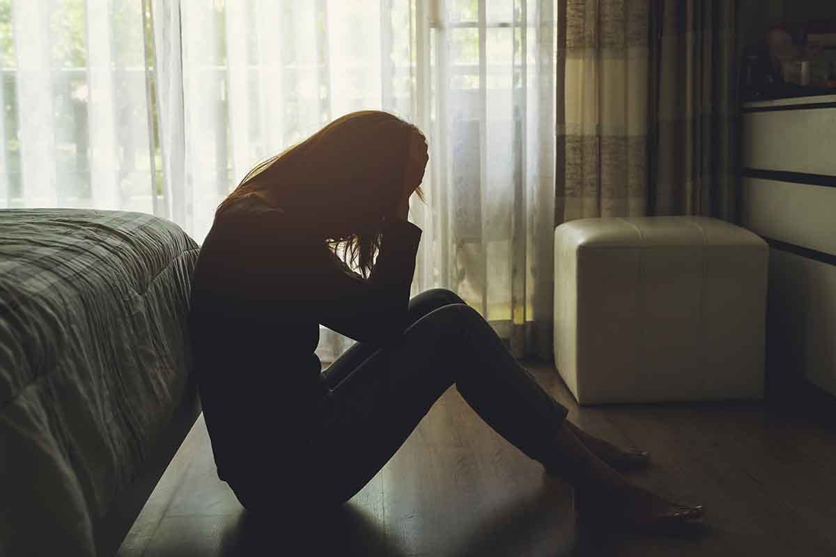individual sitting on the floor in the dark needing drug detox centers in ohio